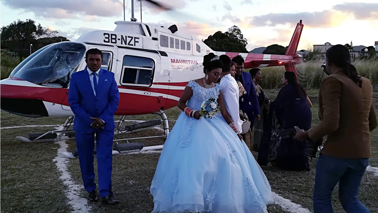 Un pilote chevronné transporte le couple en hélicoptère pour leur mariage.