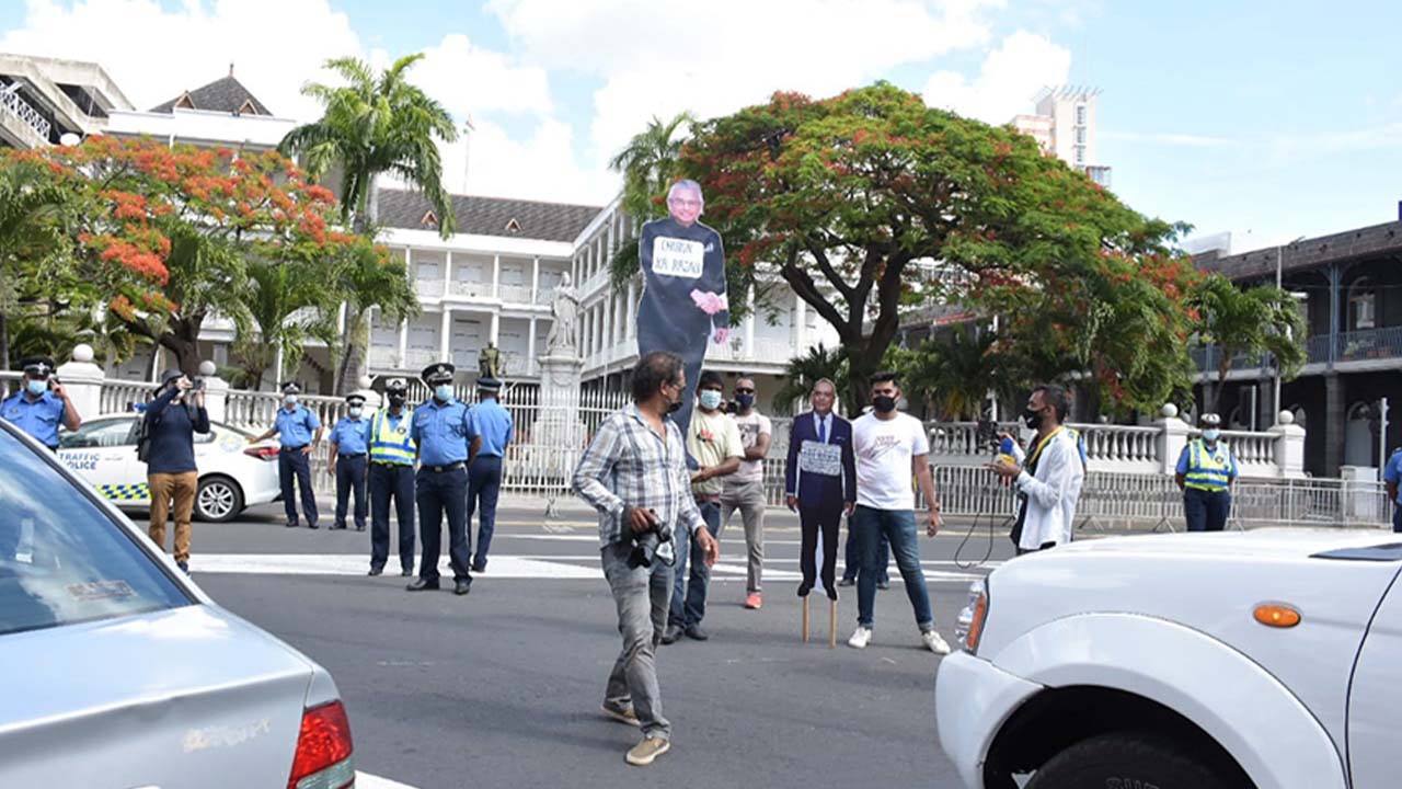Une pancarte à l’effigie du Premier ministre et une autre du Speaker ont été portées durant le défilé, comme ici devant la Government House, à la Place d’Armes.
