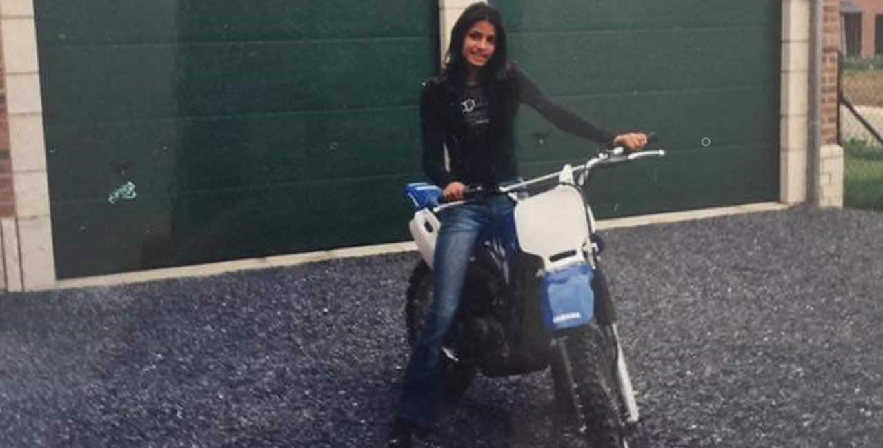 La jeune femme est fan de moteurs ! Sur cette photo, elle a 13 ans et pose sur une moto en Belgique.
