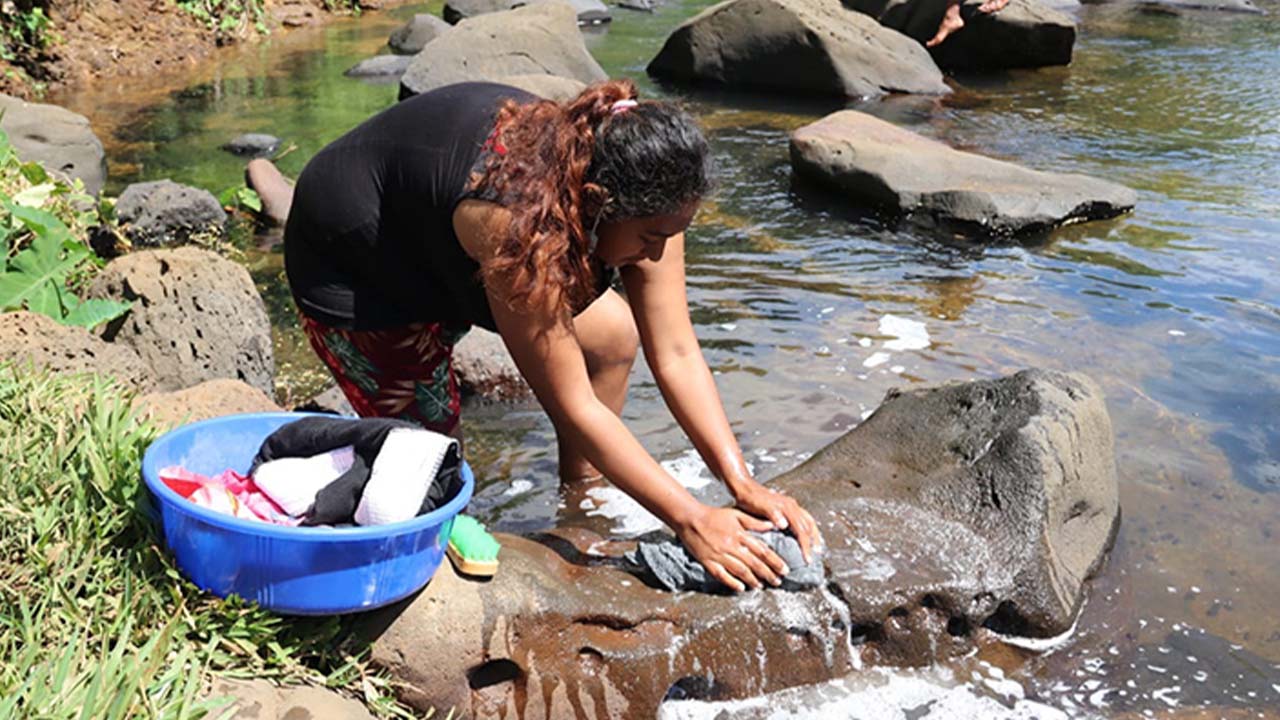 Pour laver le linge, les femmes se rendent à la rivière de Beau-Vallon.