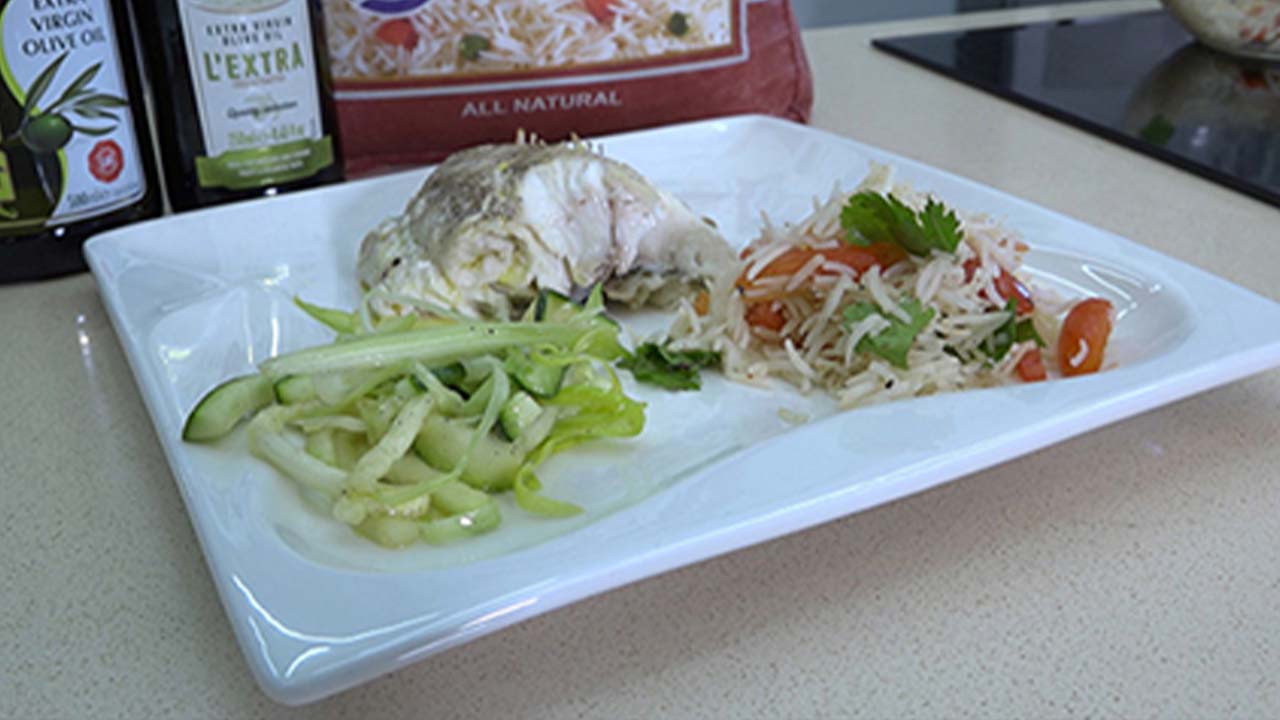 Le poisson grillé accompagné de salade de riz et salade verte.