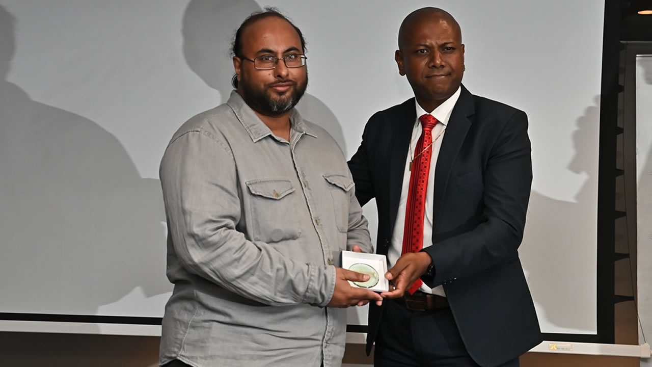 Utam Ramchurn recevant son prix des mains de Jean-Marie Gungaram, membre du board du Media Trust.