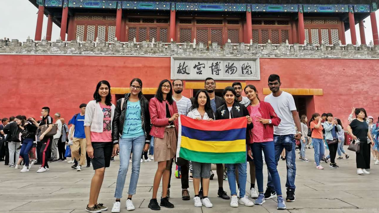 Les étudiants Mauriciens posent fièrement avec le drapeau Mauricien devant le Zheng Yang Men.