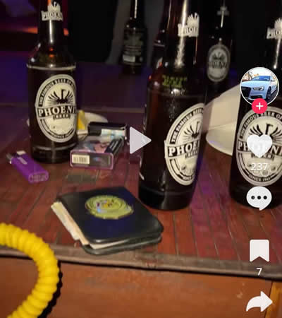 Le carnet d’un policier posé sur une table à côté de bouteilles de boissons alcoolisées.