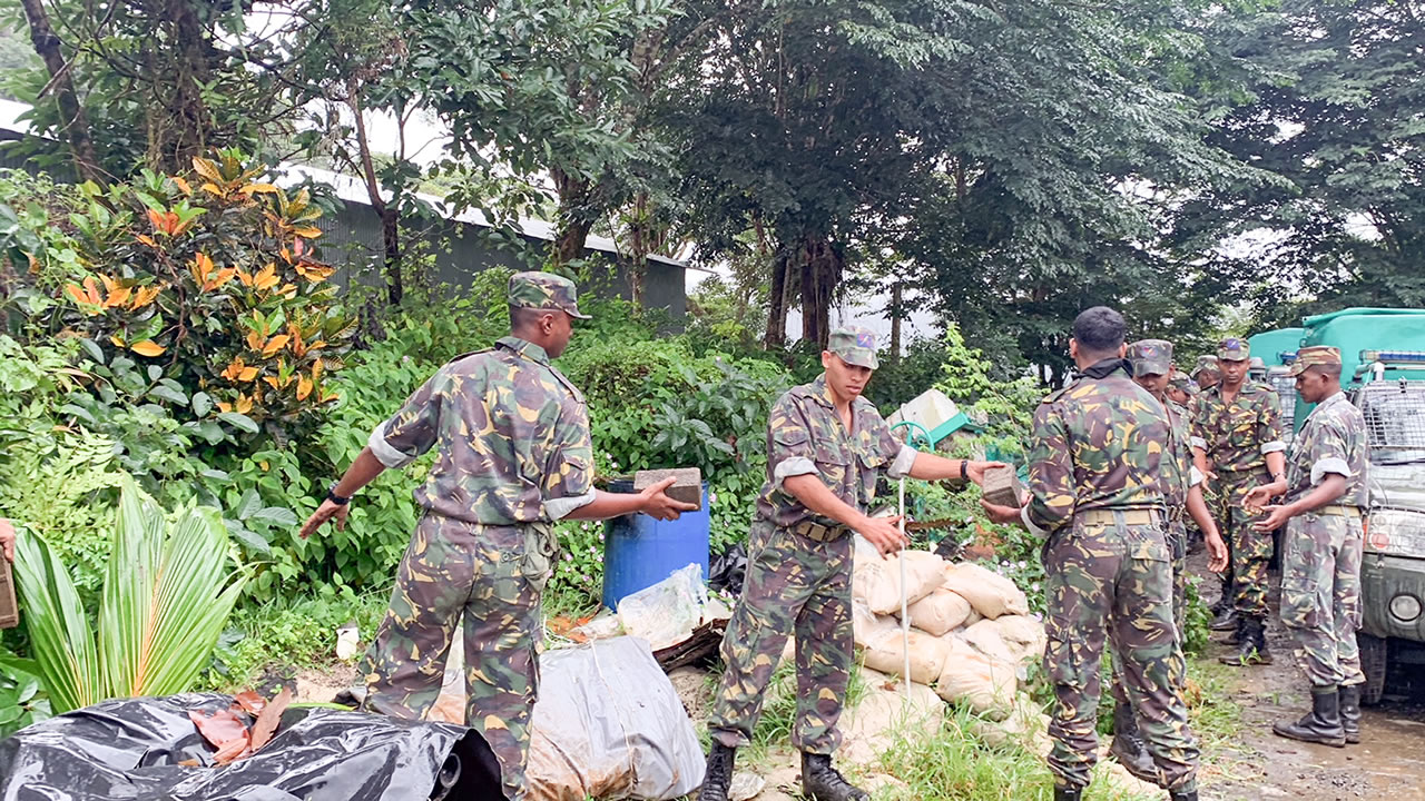 Des membres de la Special Mobile Force déplaçant les matériaux découverts sur le terrain de Vidarmen Payen à Cluny.