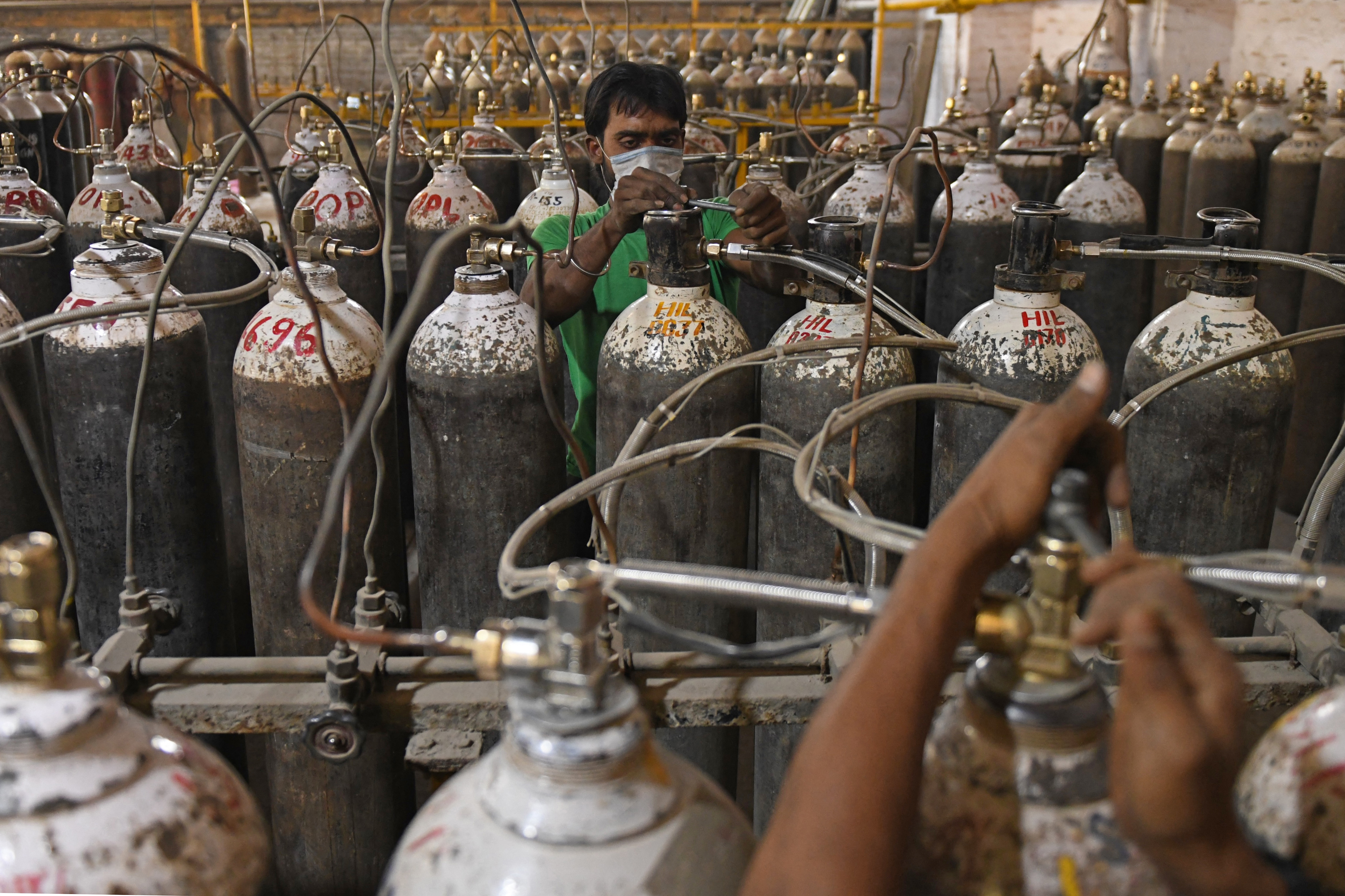 Des travailleurs sont vus en train de trier des bouteilles d'oxygène qui sont utilisées pour les patients atteints du Covid-19 avant de les envoyer aux hôpitaux dans une installation à la périphérie d'Amritsar, le 28 avril 2021