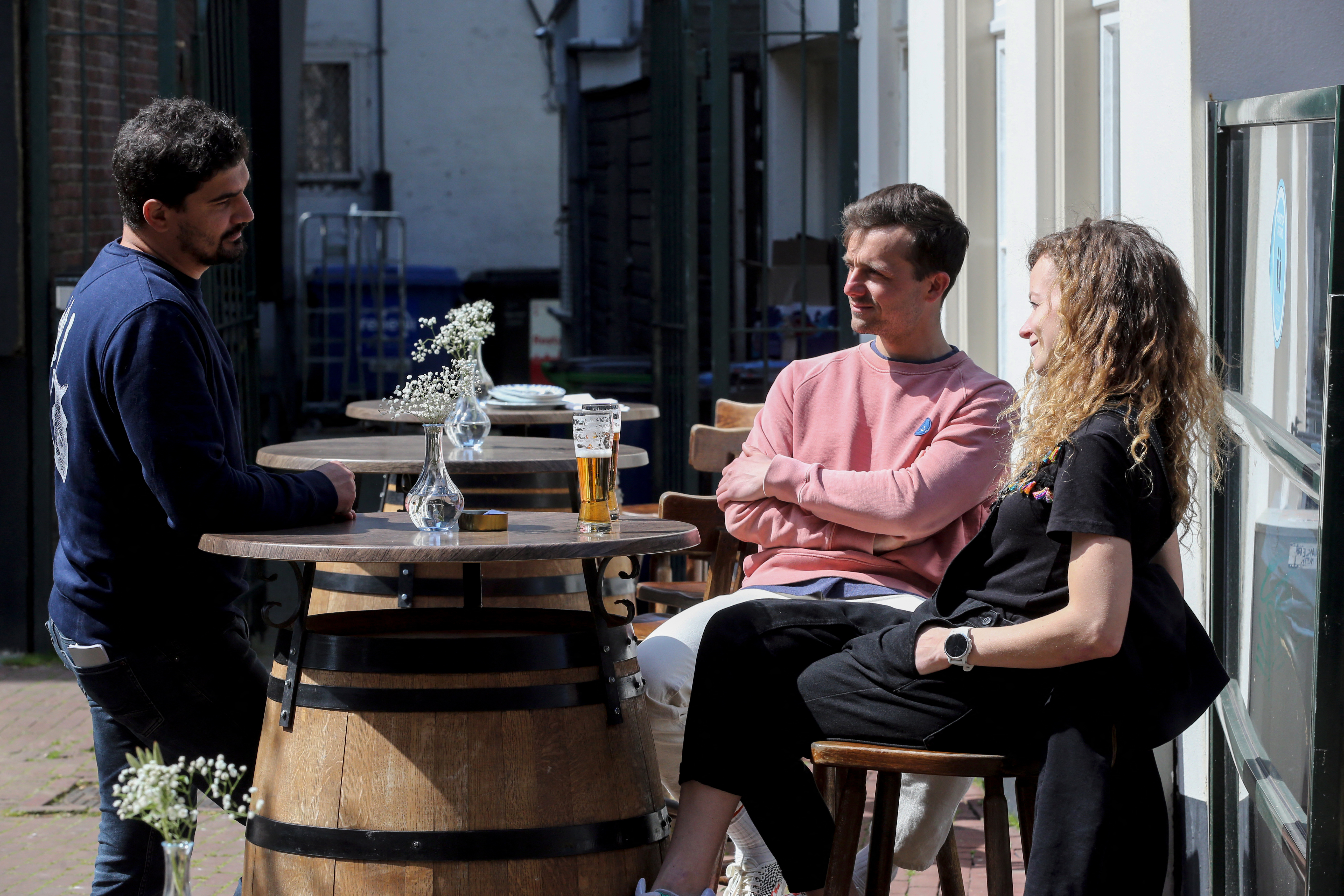 Des clients sont assis sur une terrasse à Amsterdam, le 28 avril 2021, alors que le gouvernement néerlandais a assoupli les restrictions mises en place pour freiner la propagation du Covid-19