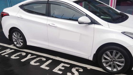 Une voiture stationnée sur un parking réservé aux deux-roues