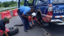 Un policier aide un automobiliste à changer un pneu