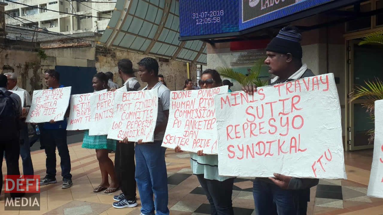 Les syndicalistes et des employés devant les locaux du ministère du Travail.