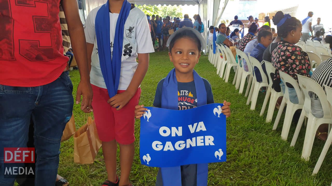 Slogan « on va gagner » dans les mains d’un petit garçon qui a accompagné ses parents au meeting.
