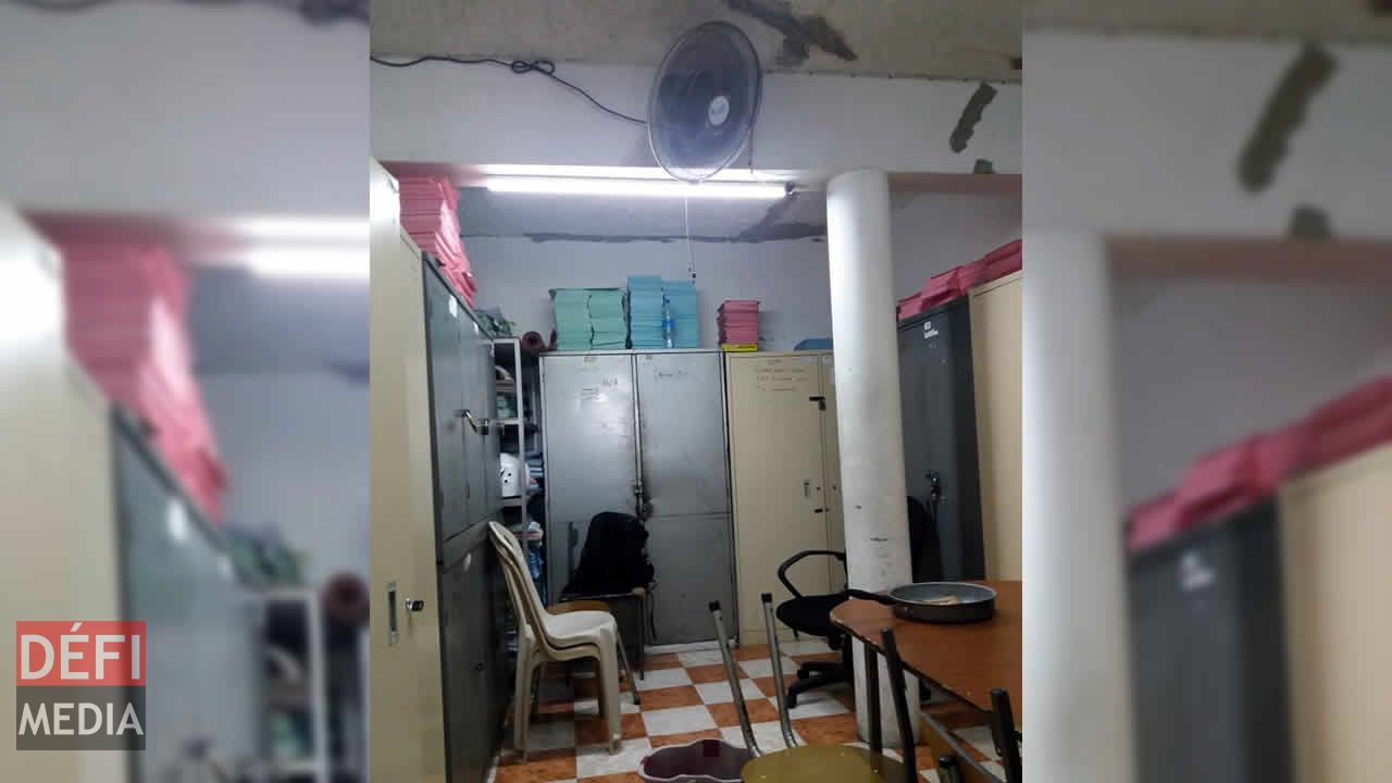 Des chaises sans dossier de même qu’un seau et un poêlon pour contenir l’eau qui coule du plafond. Sapeurs-pompiers