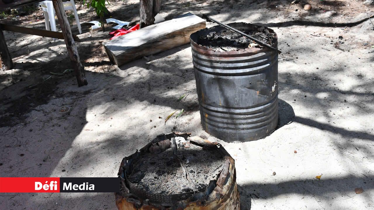Des fûts métalliques abandonnés, remplis de charbon consumé.