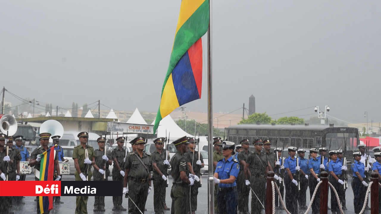 Le lever du drapeau sous une pluie battante, au son de l’hymne national.