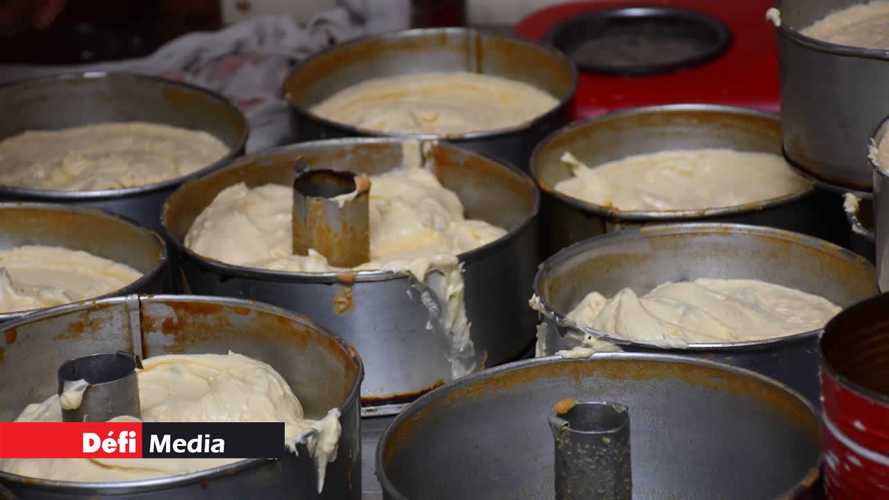 Un assortiment de moules en métal reçoit la pâte fraîchement préparée, reflétant l’anticipation de la délicatesse à venir.