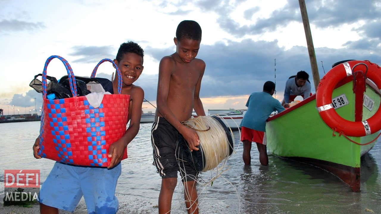 Des enfants qui donnent un coup de main aux pêcheurs revenus de la mer. pêcheur