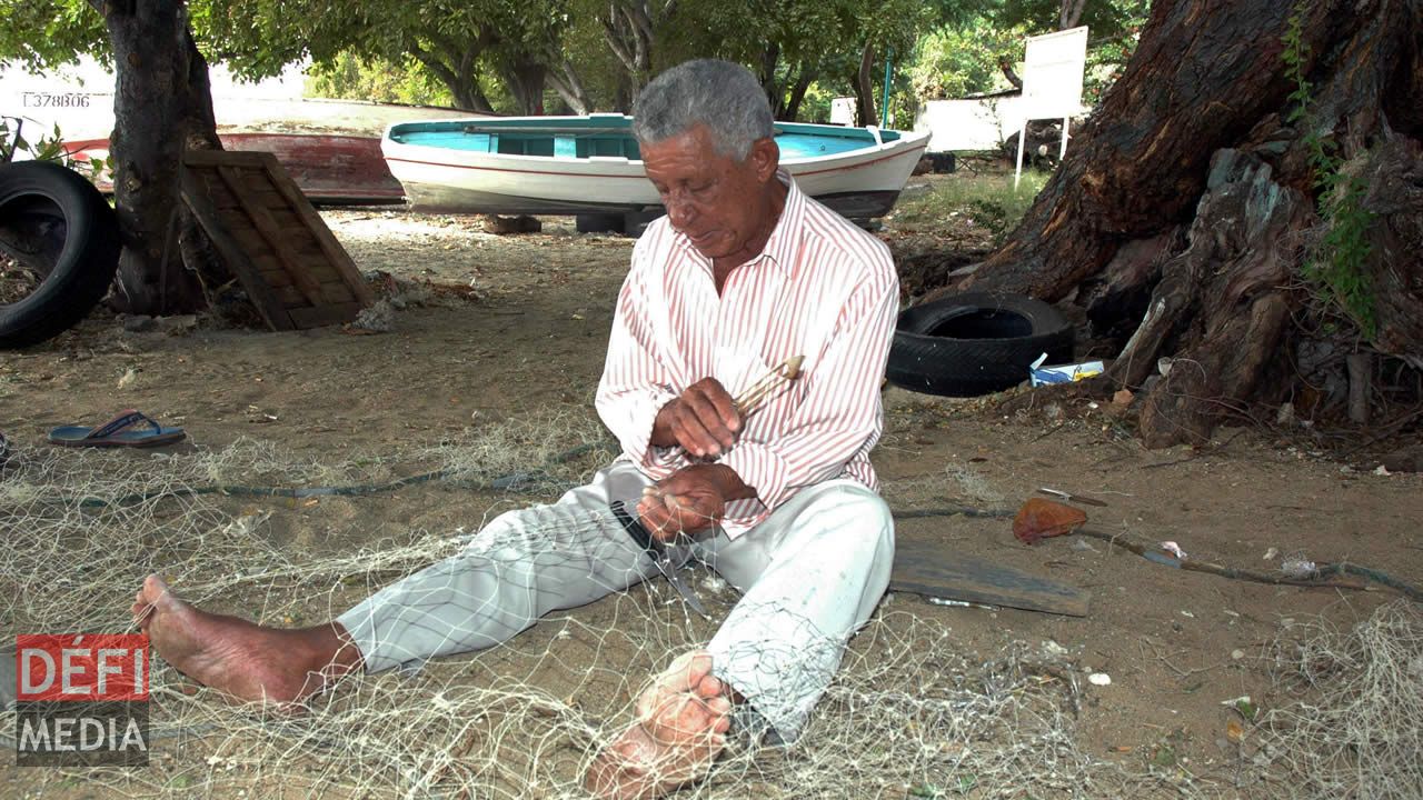 Un vieux pêcheur tissant son filet avant de prendre la mer. pêcheur