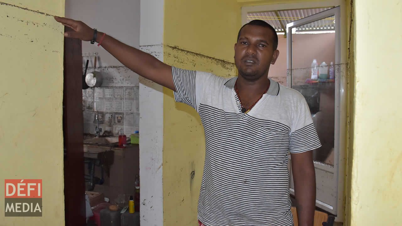 Leckraj, le mari de Vandana, indiquant jusqu’où l’eau est montée dans sa maison. Leckraj, le mari de Vandana, indiquant jusqu’où l’eau est montée dans sa maison.