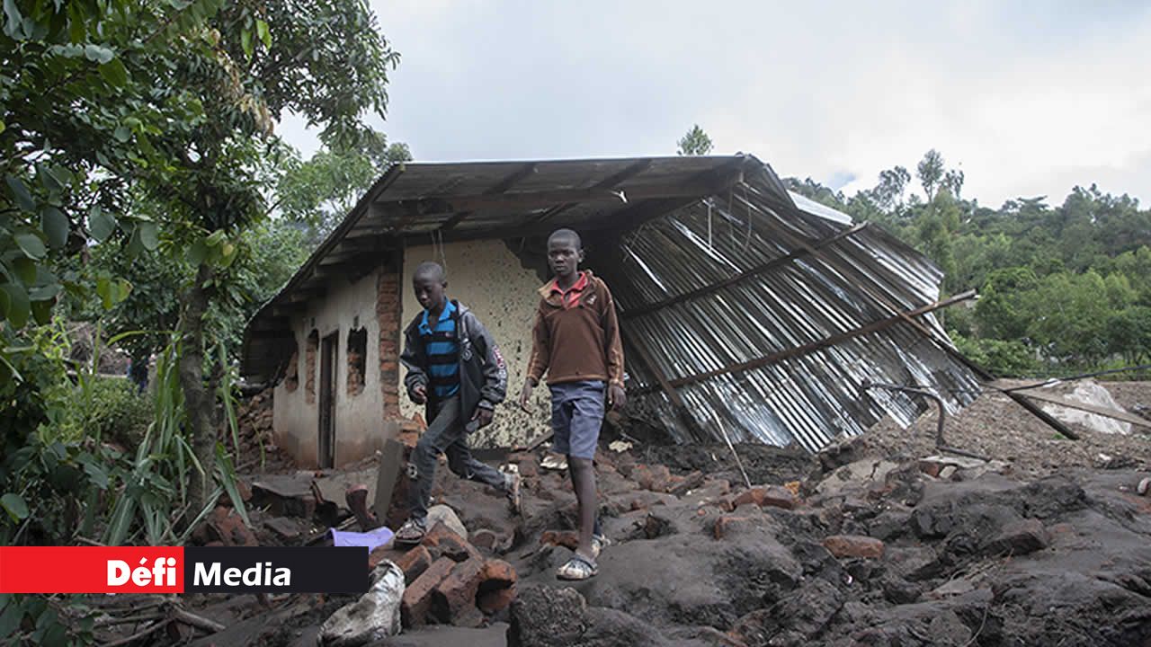 Des garçons passant près d’une maison détruite par un glissement de terrain dans le sud du Malawi.