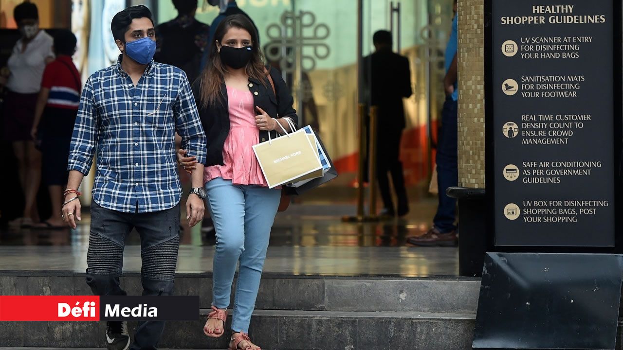Un couple portant un masque comme mesure préventive contre la COVID-19 devant le centre commercial Palladium à Mumbai le 16 août 2020