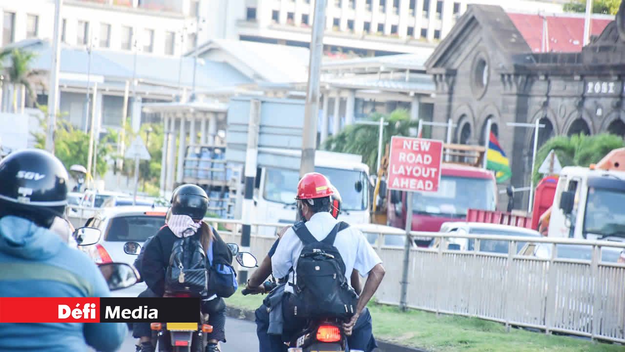 Un passager en croupe qui porte un casque de chantier au lieu d’un casque moto.