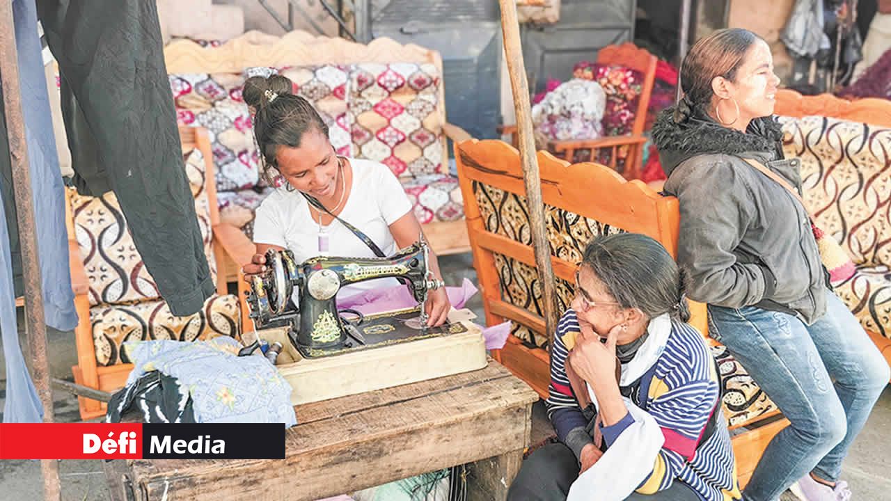 Sur le bord de la route, beaucoup de couturières travaillent. Cette dame fait une robe pour sa cliente qui attend la livraison.
