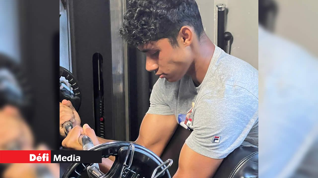 concept de sport et de loisirs. un homme sportif musclé et mal rasé tient  des haltères lourds dans les mains, pose avec un torse nu, a des biceps  forts, concentré à distance