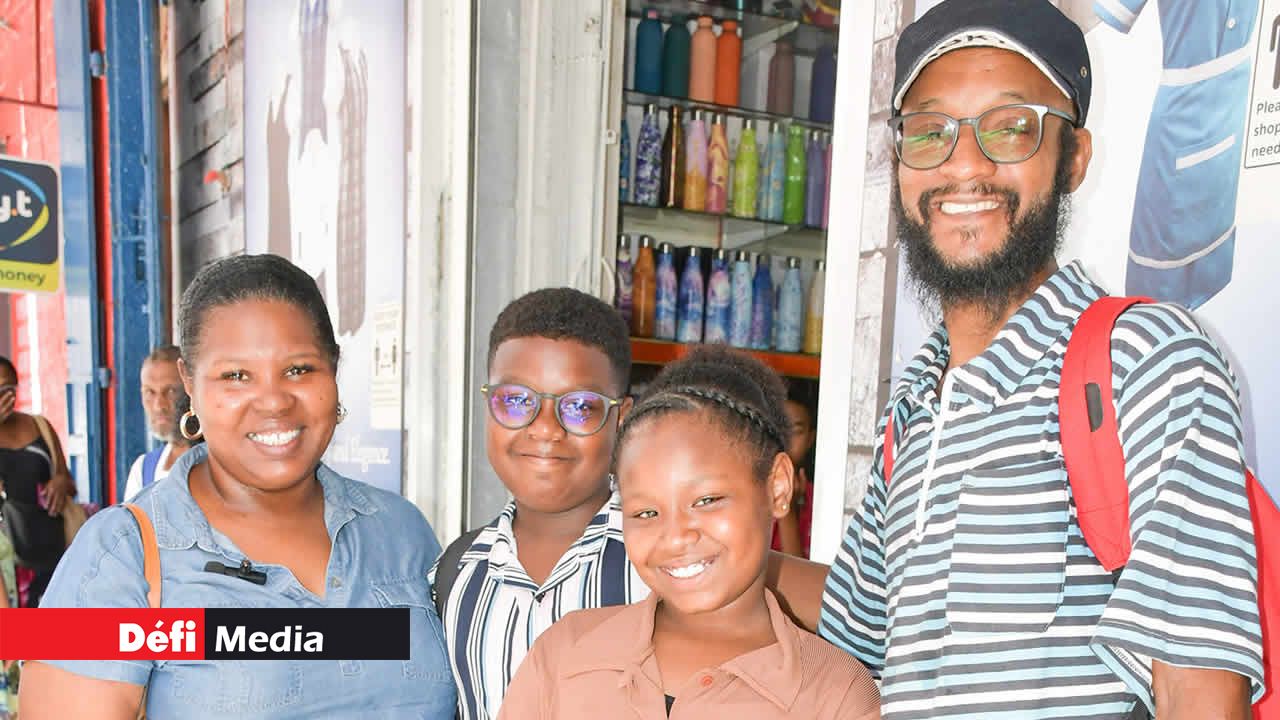 Joelle, accompagnée d’Ethan, Ethana et Ti-Georges, originaires de Roche-Bois, passe commande pour les uniformes et le matériel scolaire de ses enfants. Leur souhait au père Noël ? Une rentrée réussie, avec son fils qui s’apprête à intégrer le secondaire.