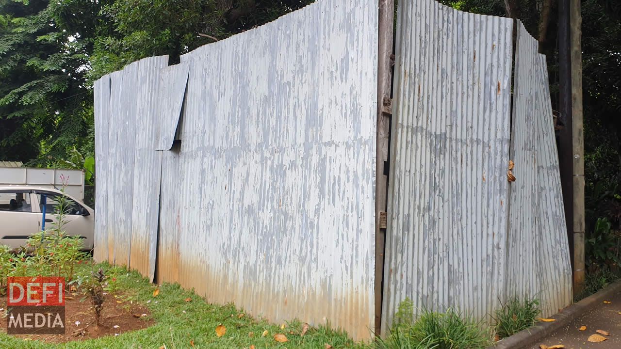 Dans la cour du musée de Mahébourg se trouve une structure en tôle cannelé, derrière laquelle se cache un ancien wagon de passagers tombant en décrépitude.