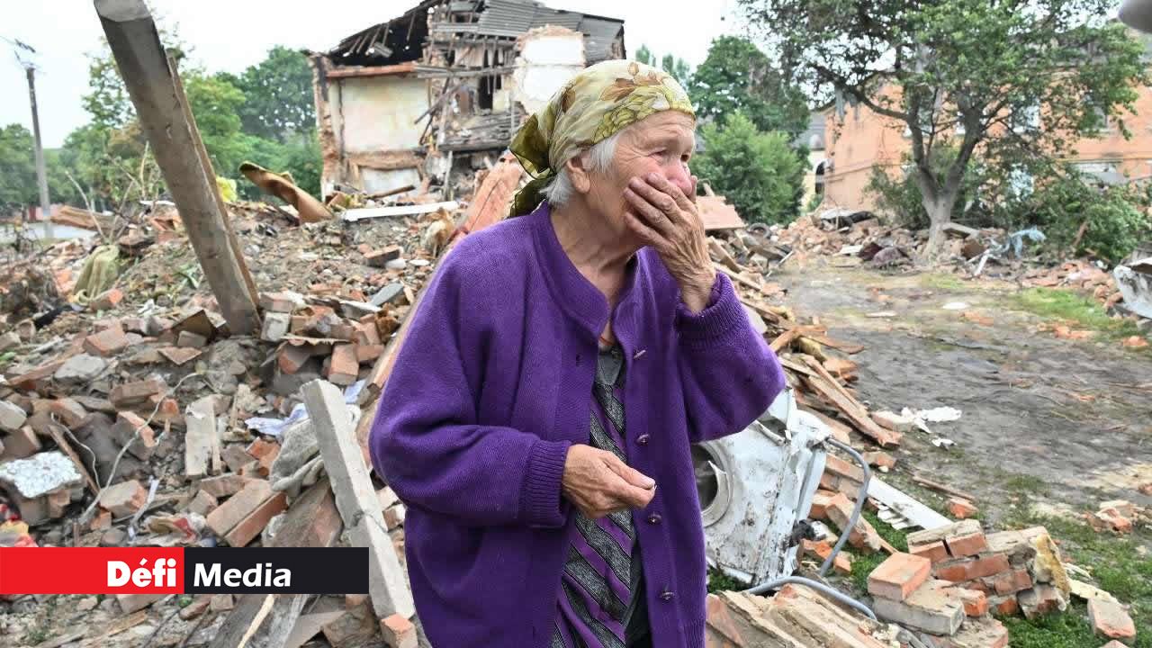 Raisa Kuval, 82 ans, réagit à côté d'un bâtiment endommagé partiellement détruit après un bombardement dans la ville de Chuguiv, à l'est de Kharkiv, en Ukraine, le 16 juillet 2022