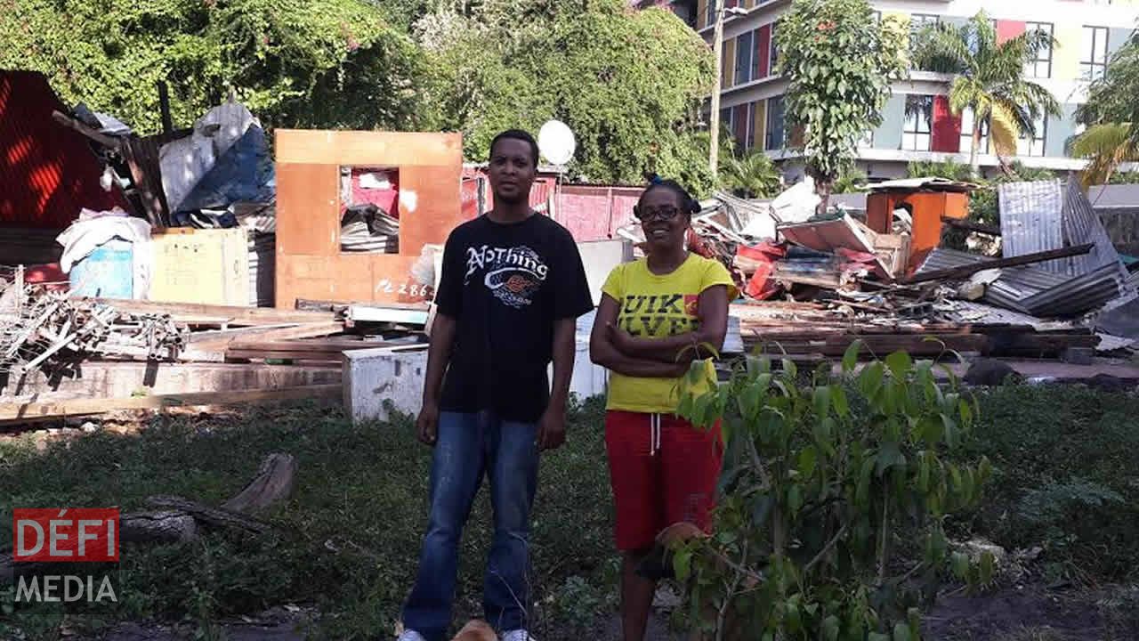 Marie-Lourdes Bengali
devant sa case en tôle démolie.