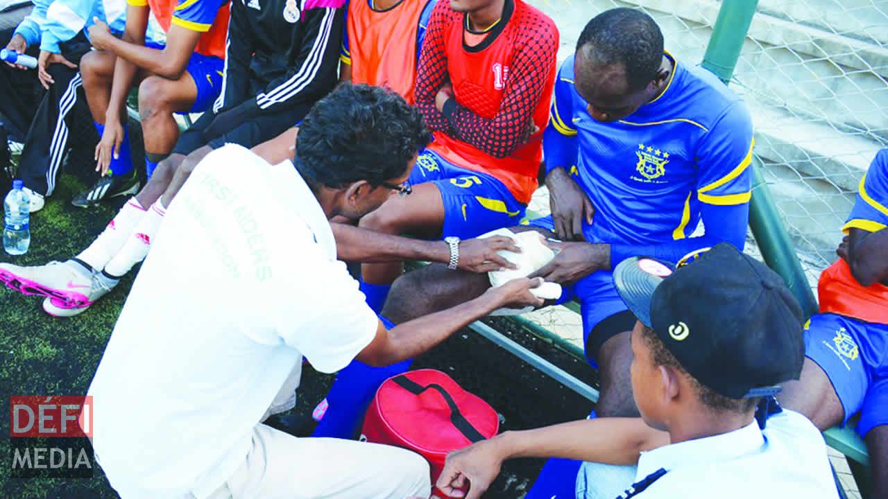 Linganaden Munien et Emmanuel Collard prodiguent les premiers soins à Rock Durand.