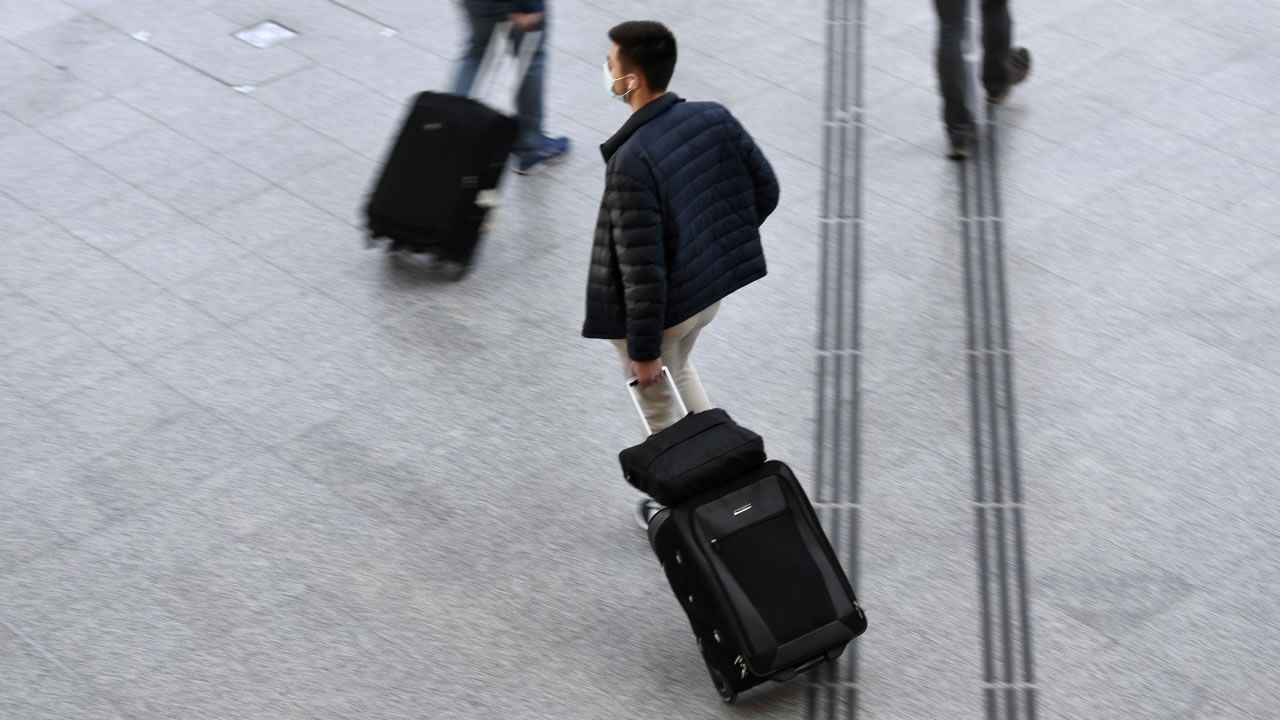 Un homme portant un masque facial marche avec un bagage dans le hall de départ de la gare de Lyon à Paris, le 18 décembre 2020, à la veille du début des vacances